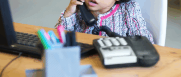 little girl seated at office desk