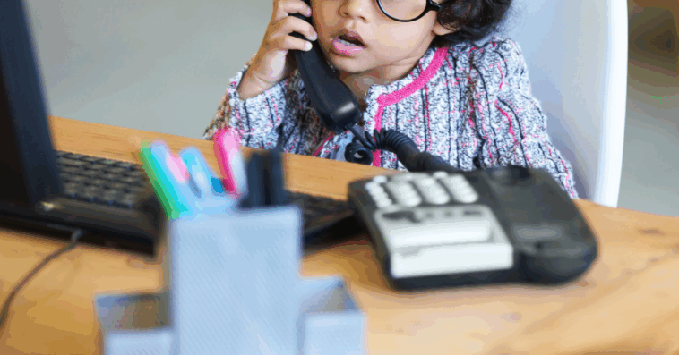 little girl seated at office desk