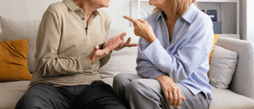 older couple seated on couch arguing