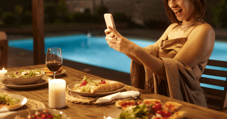 woman filming with phone at dinner