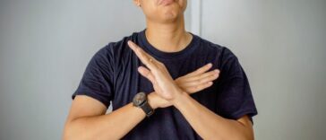 unhappy young man with hands crossed in front of him