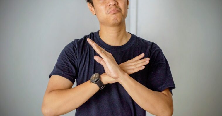 unhappy young man with hands crossed in front of him