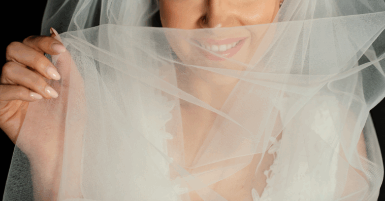 A bride covering her face with a veil.