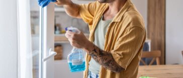 A man cleaning windows at home, ensuring a clear and fresh view. This scene emphasizes the importance of home maintenance and creating a tidy, pleasant living environment.