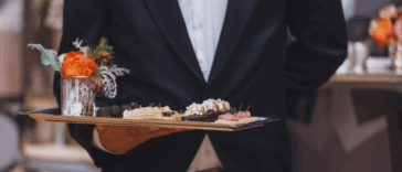A waiter holding a tray of appetizers.