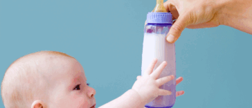 Baby reaching for bottle