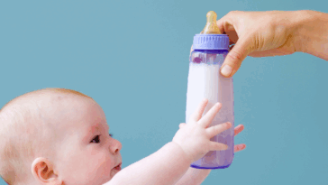 Baby reaching for bottle
