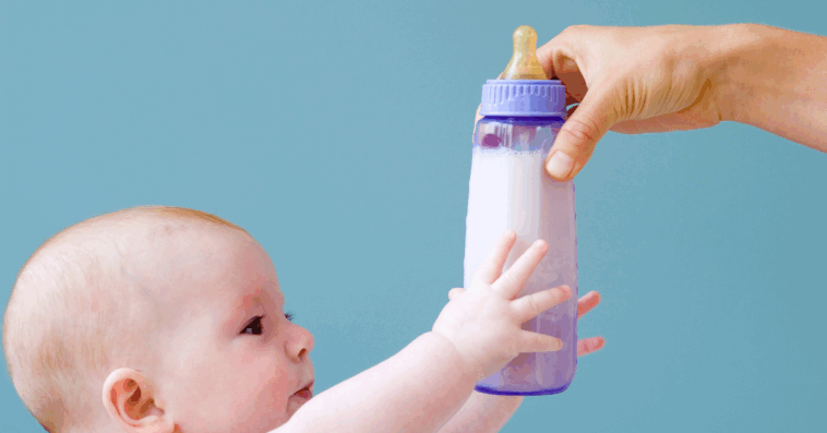 Baby reaching for bottle