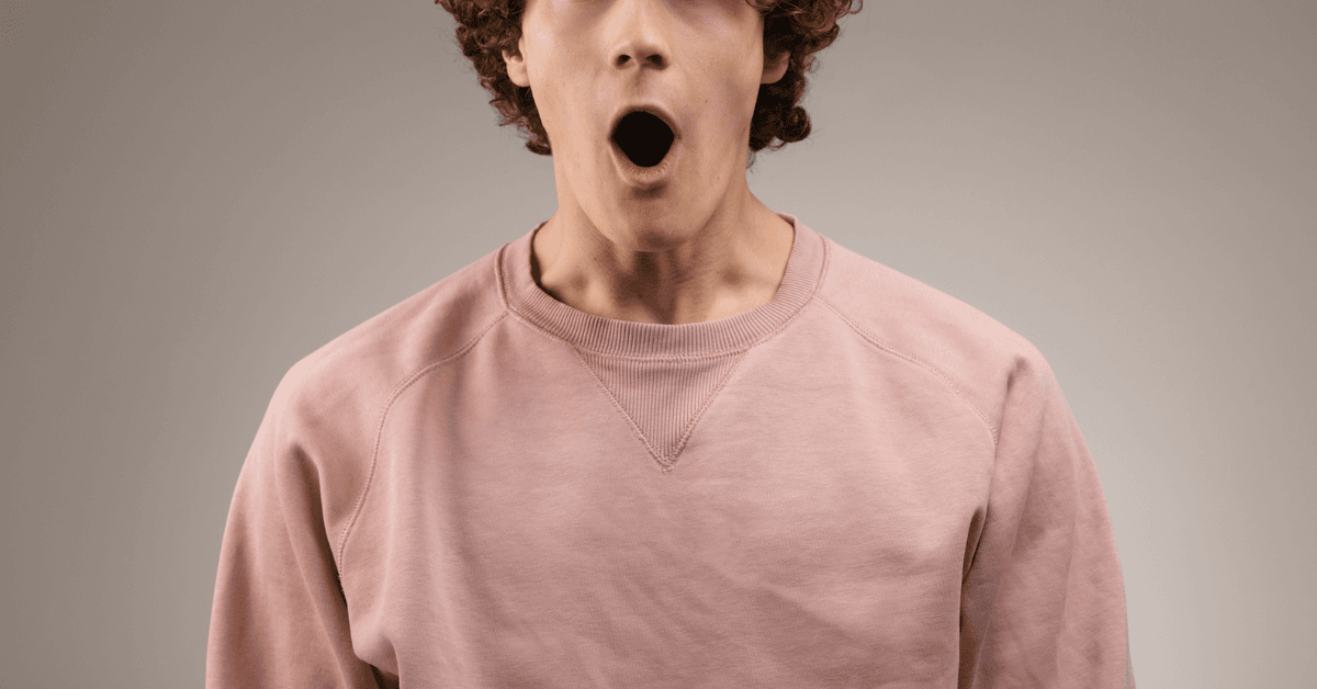 A man with facing forward with his mouth wide open.