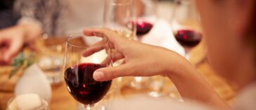 Close-up of female holding glass with red wine.
