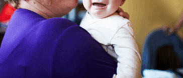A woman holding a crying baby.