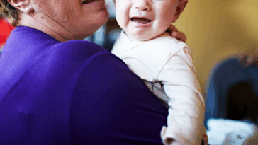 A woman holding a crying baby.