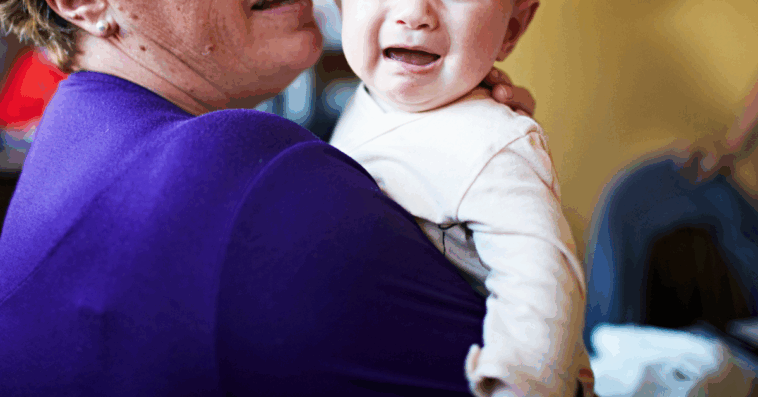 A woman holding a crying baby.