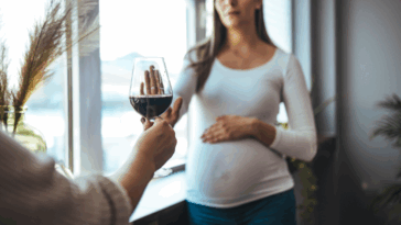 pregnant woman refusing a glass of wine