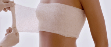 woman having breasts wrapped after cosmetic procedure