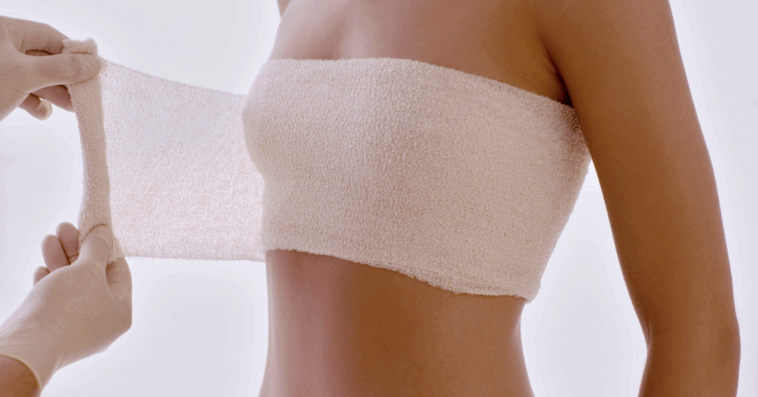 woman having breasts wrapped after cosmetic procedure