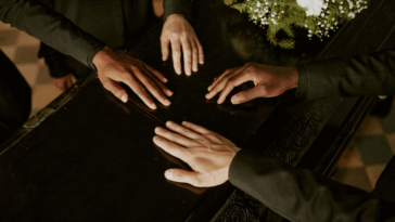 hands on a casket lid