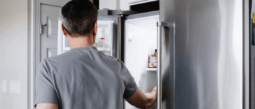 man looking in refrigerator
