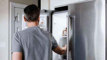 man looking in refrigerator
