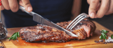 man cutting a steak