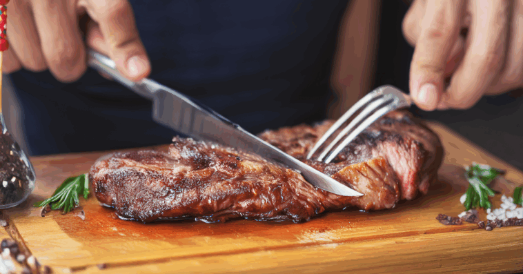 man cutting a steak
