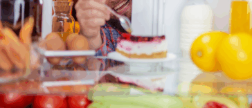 man eating out of refrigerator