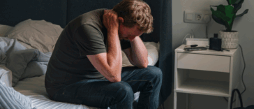 upset man seated on a bed