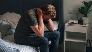 upset man seated on a bed