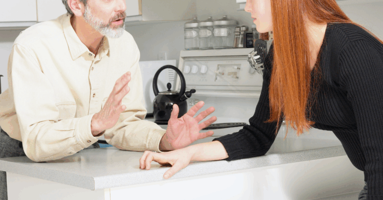 older man and younger woman arguing in kitchen