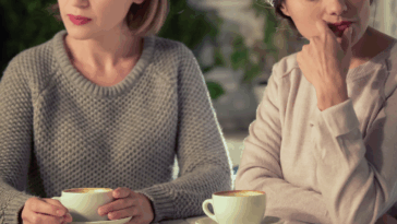 two unhappy women drinking coffee