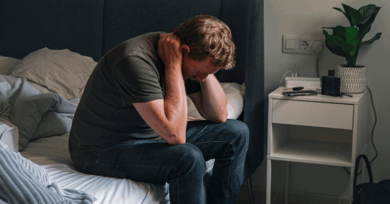 upset man seated on a bed