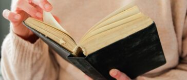 Close-up of a woman's hands turning the pages of a book.