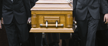 A group of pallbearers carrying a casket.