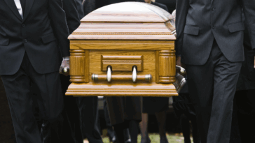A group of pallbearers carrying a casket.