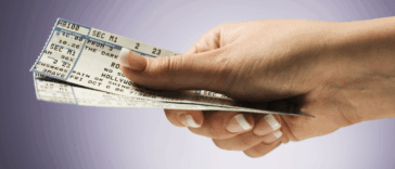 A person holding a pair of concert tickets