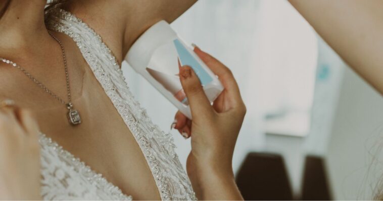 The Maid Of Honor Applies Antiperspirant To The Bride's Armpits.