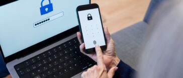 A faceless adult's hands accessing a smartphone and laptop with fingerprint for enhanced security and seamless login experience.
