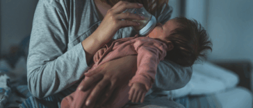 A woman feeding a baby with a bottle.