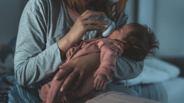 A woman feeding a baby with a bottle.