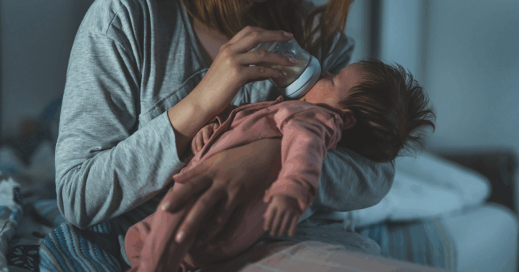 A woman feeding a baby with a bottle.