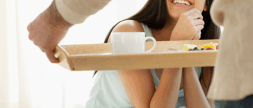 man serving woman food on tray