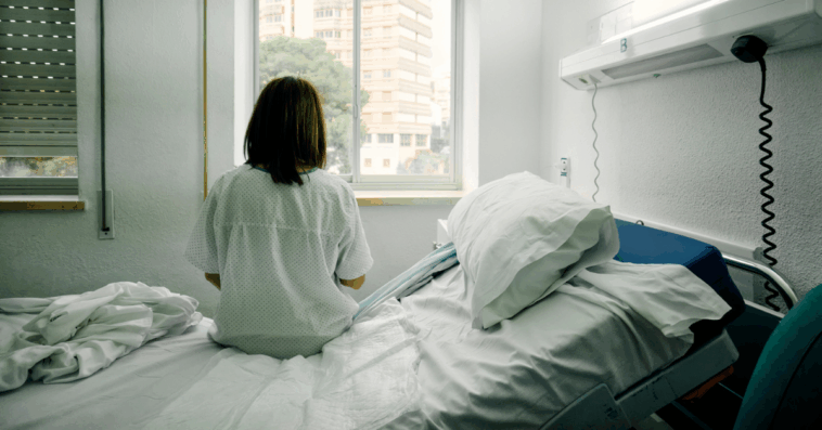 woman sitting alone on hospital bed