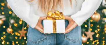 person holding wrapped gift behind their back