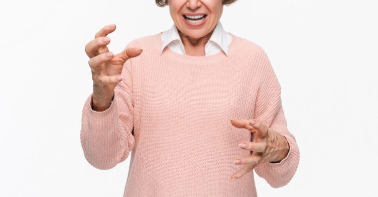 Angry mature woman on white background. Portrait of elderly senior lady grandmother feeling frustrated expressing anger, mad, upset, hostile, shouting isolated on light background.