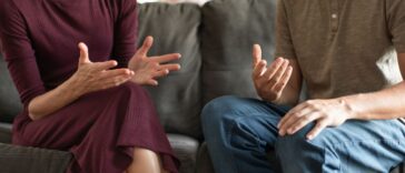 Couple sitting at home talking, having conversation. People discussing domestic issues, argument, working out problems.