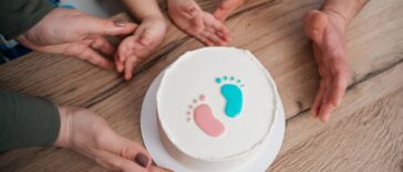 Family looking at a gender reveal cake, celebrating the upcoming birth of a baby.