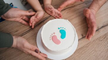 Family looking at a gender reveal cake, celebrating the upcoming birth of a baby.