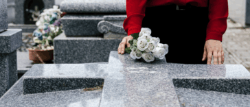 A woman standing at a grave.