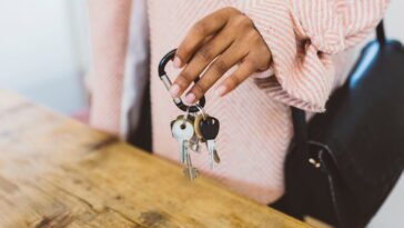 Mid-shot of a woman coming home, putting keys on the table.