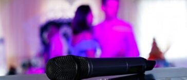 Close up on a microphone, on stage of a business meeting or event with flare light effect and copyspace.